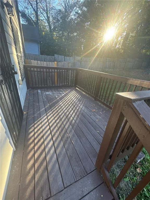 Wooden terrace with a fenced backyard