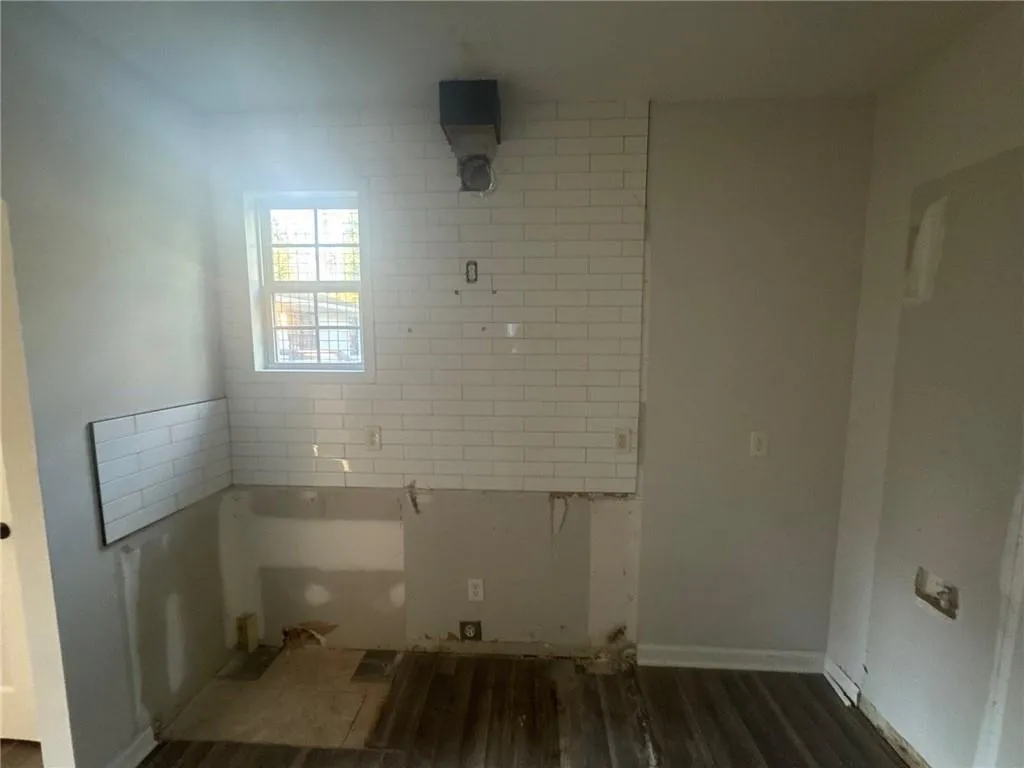 Unfurnished room featuring dark wood-style flooring and baseboards