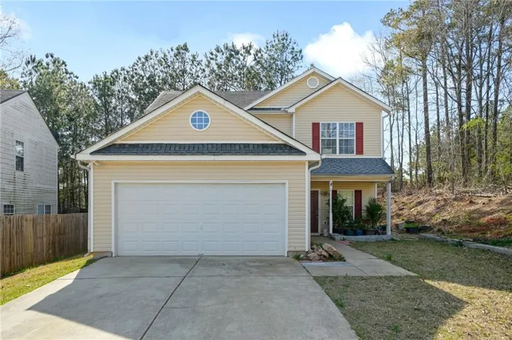 Traditional-style house featuring concrete driveway, a porch, roof with shingles, and a garage