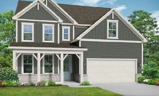Two-story residence featuring a covered front porch, white garage door, dark siding, and light trim details