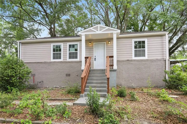 Front facade featuring horizontal siding and a brick foundation