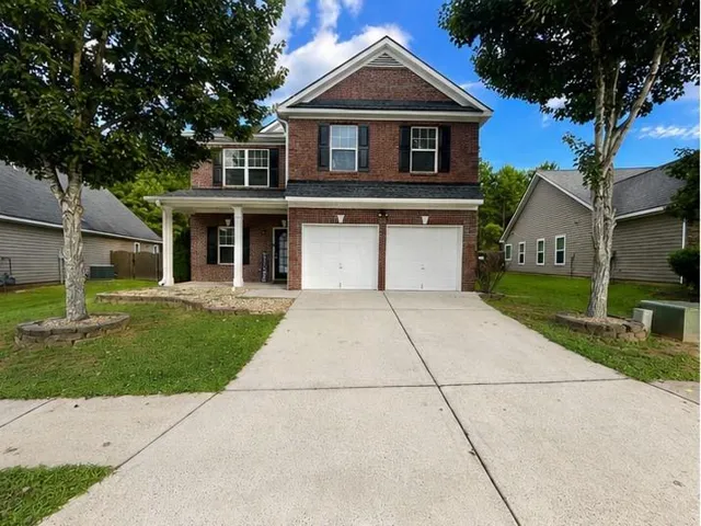 Brick exterior with a covered porch, two-car garage, and concrete driveway