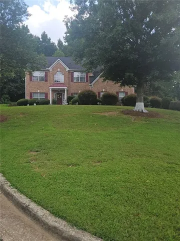 Brick facade colonial-style residence with a gabled roof and white trim
