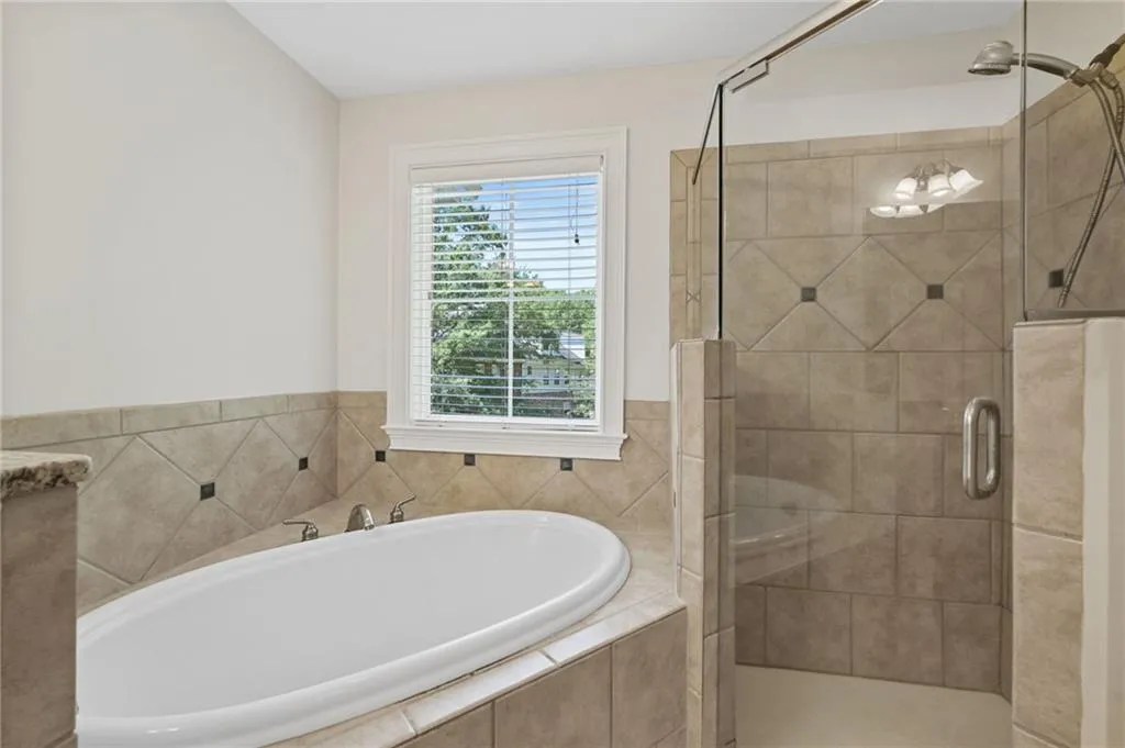 Primary features soaking tub and separate shower.