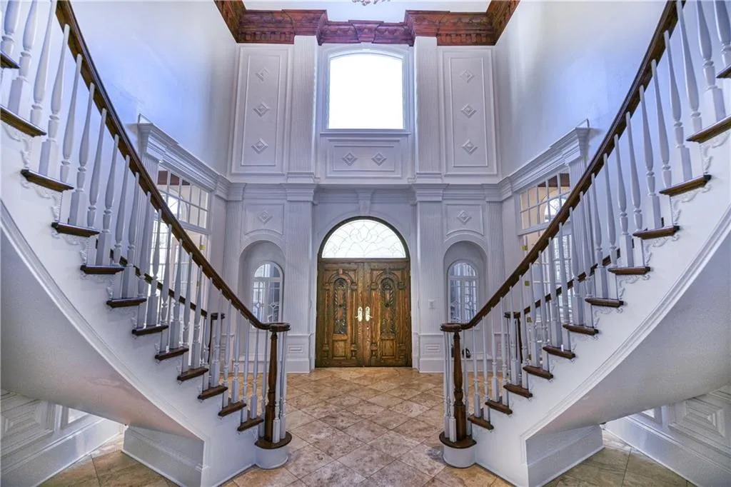 Foyer featuring stairs, a high ceiling, and crown molding