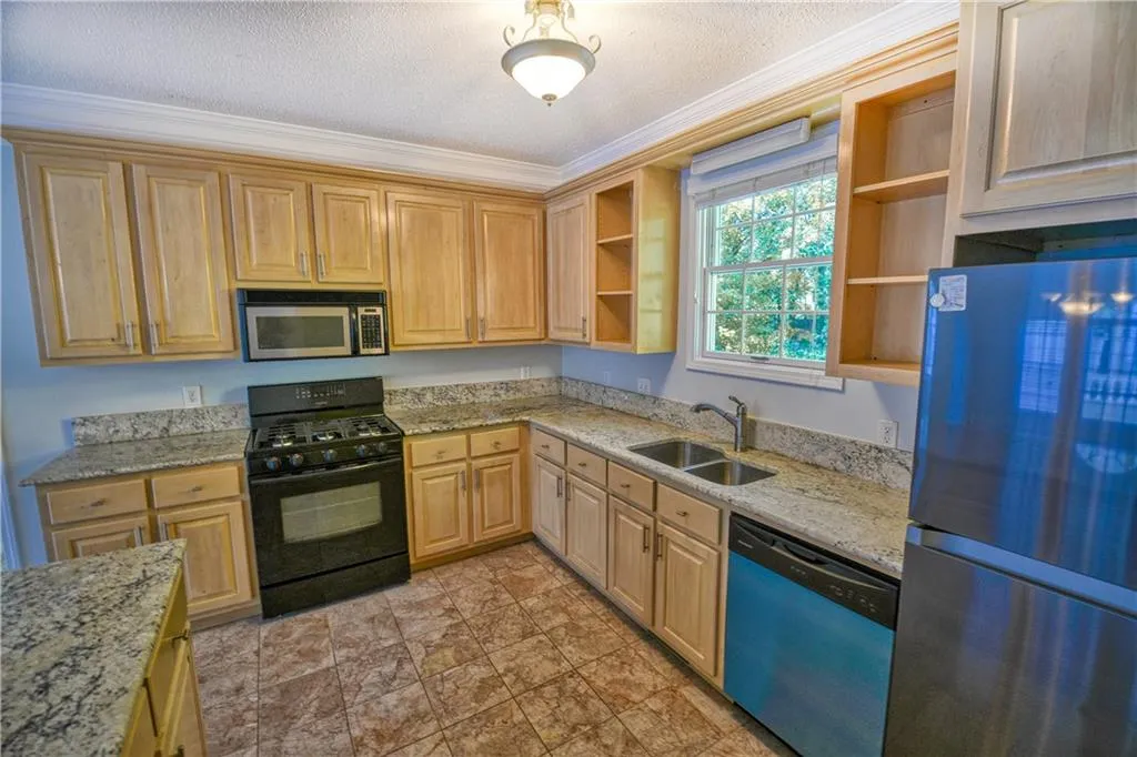 Kitchen with open shelves, stainless steel appliances, a textured ceiling, a sink, and light stone countertops