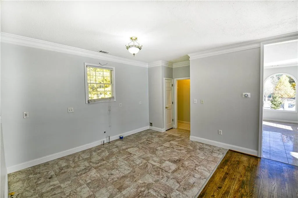 Spare room featuring crown molding, baseboards, a textured ceiling, and visible vents