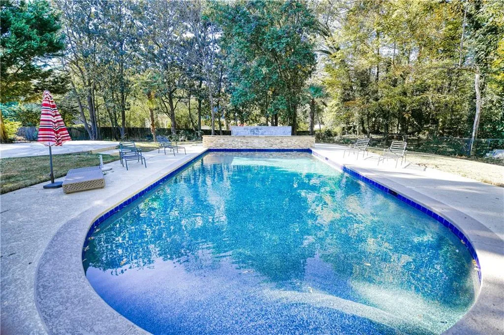 Outdoor pool featuring fence and a patio area