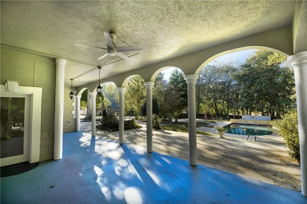 View of patio with a swimming pool and a ceiling fan