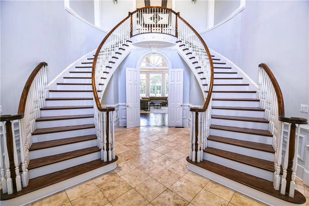 Entryway with tile patterned floors, a high ceiling, french doors, and stairway