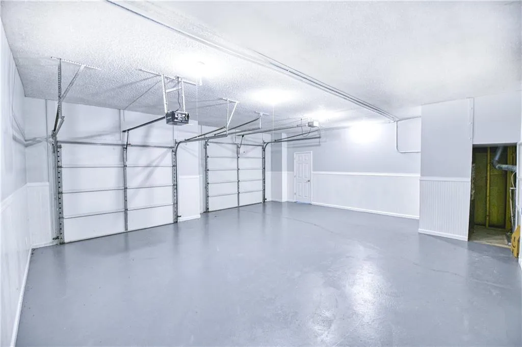 Garage featuring a garage door opener and wainscoting