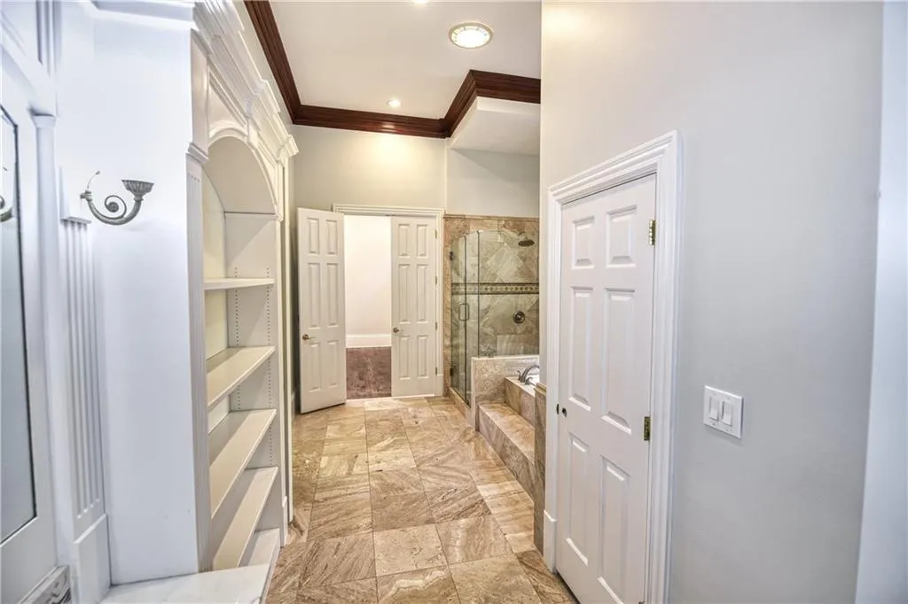 Full bath featuring a shower stall, a washtub, and ornamental molding