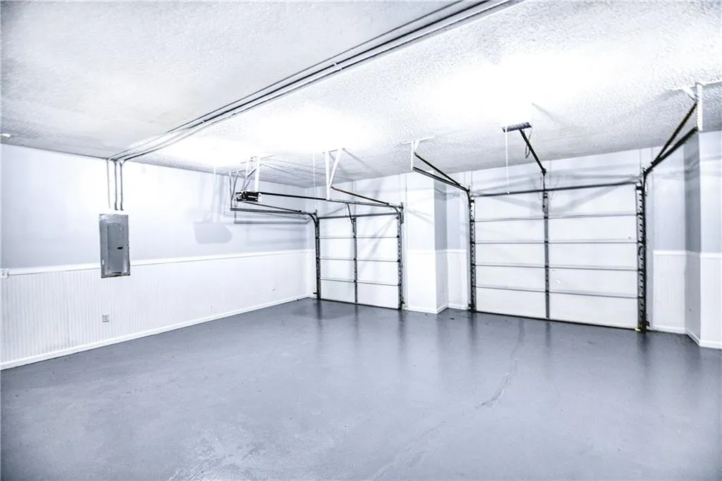 Garage featuring electric panel and a garage door opener