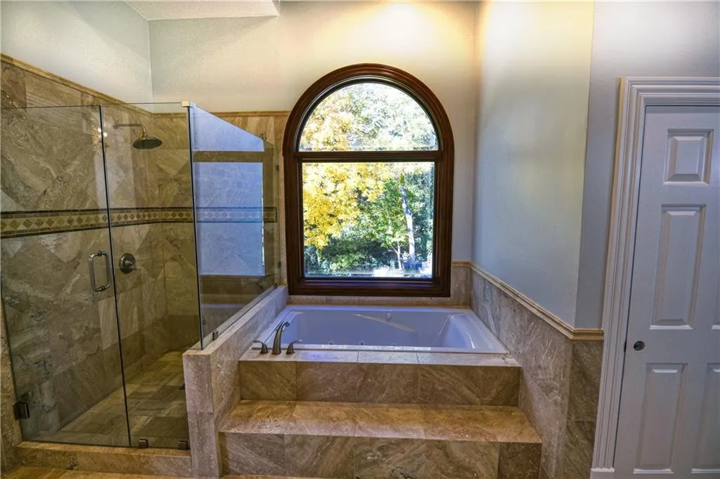 Full bath featuring a shower stall and a garden tub