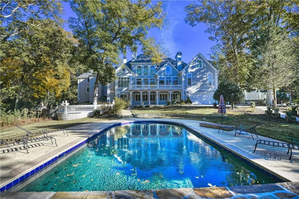 Rear view of property with fence, an outdoor pool, and a patio area