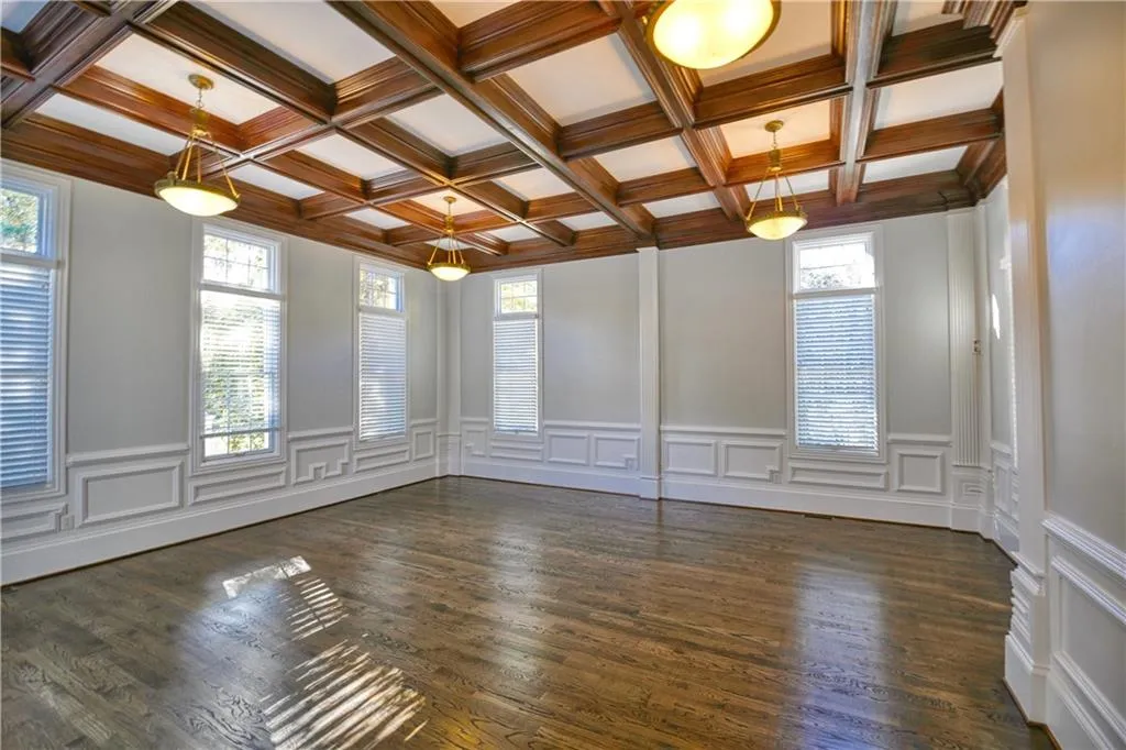 Unfurnished room featuring dark wood-style floors and a healthy amount of sunlight