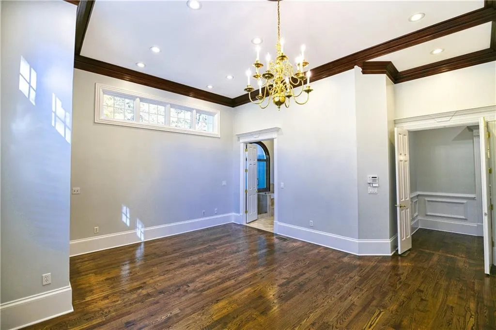 Unfurnished room with recessed lighting, ornamental molding, baseboards, a notable chandelier, and wood finished floors