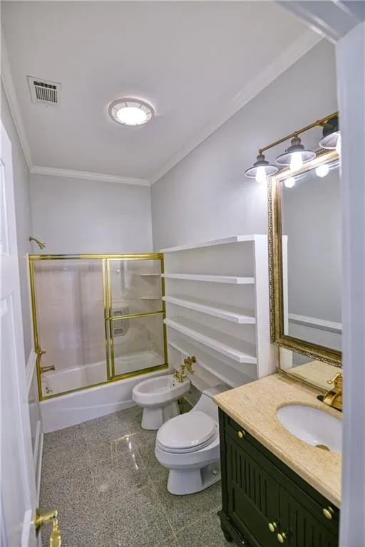Full bath featuring combined bath / shower with glass door, toilet, granite finish floor, visible vents, and ornamental molding