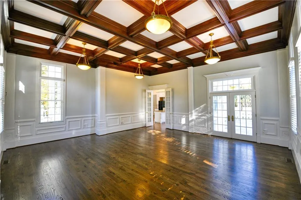 Unfurnished living room featuring french doors, dark wood-style flooring, plenty of natural light, and beam ceiling