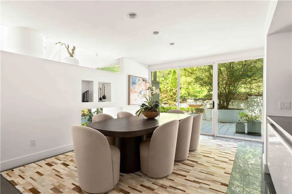 Dining space featuring floor-to-ceiling sliding glass doors, built-in wall niches, recessed lighting, and tile flooring