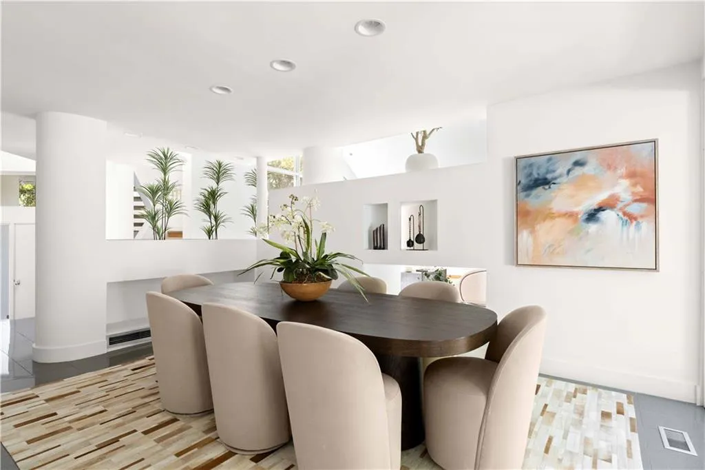 Open floor plan featuring recessed lighting, smooth-finish cylindrical architectural columns, and built-in wall niches