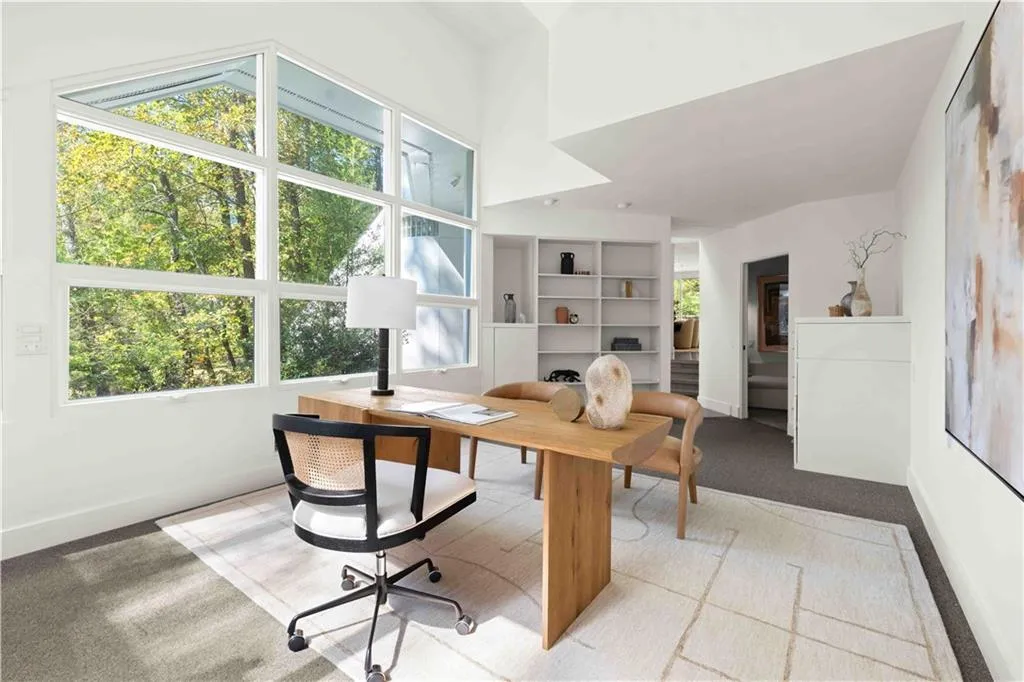 Vaulted ceiling, expansive multi-pane window configuration, built-in shelving, and neutral wall-to-wall carpeting