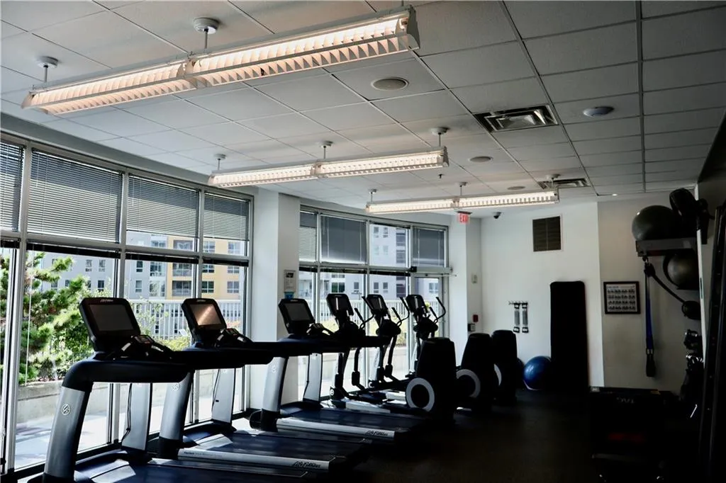 Exercise room with a paneled ceiling and a wall of windows