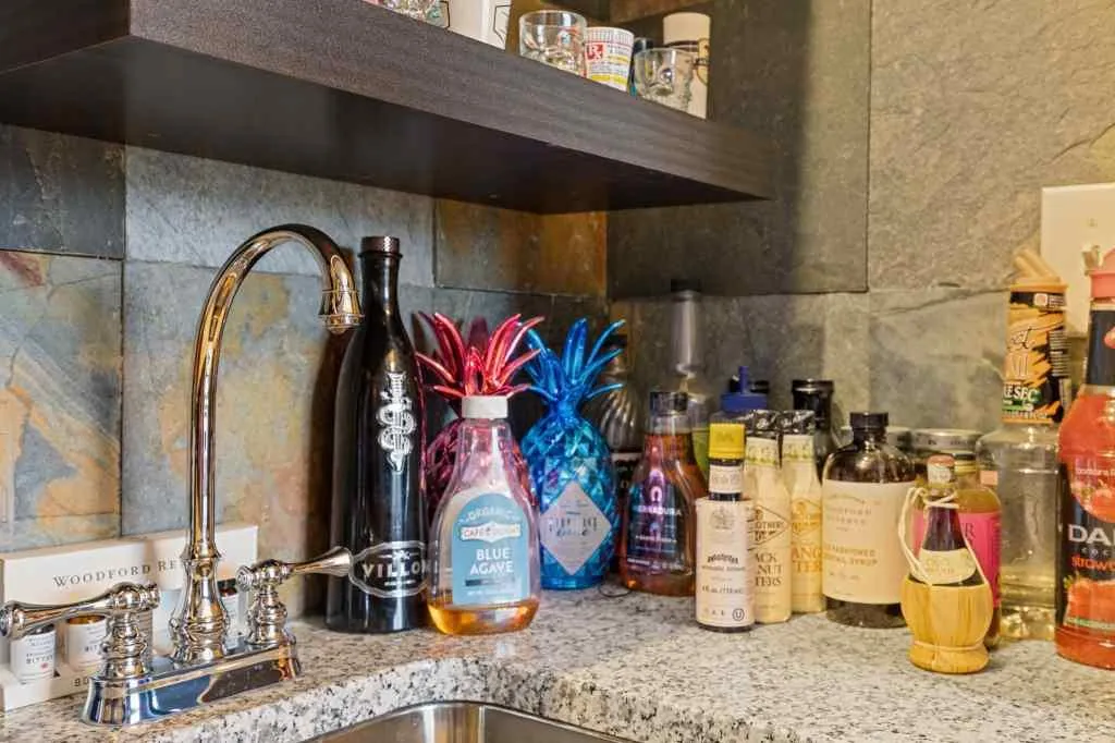 The second bedroom has been made into a lounge type room with a beautiful built in bar.  The bar features a wine fridge, cabinets, floating shelves and bar sink. This is a great space for relaxing or for entertaining. This could be removed if someone want