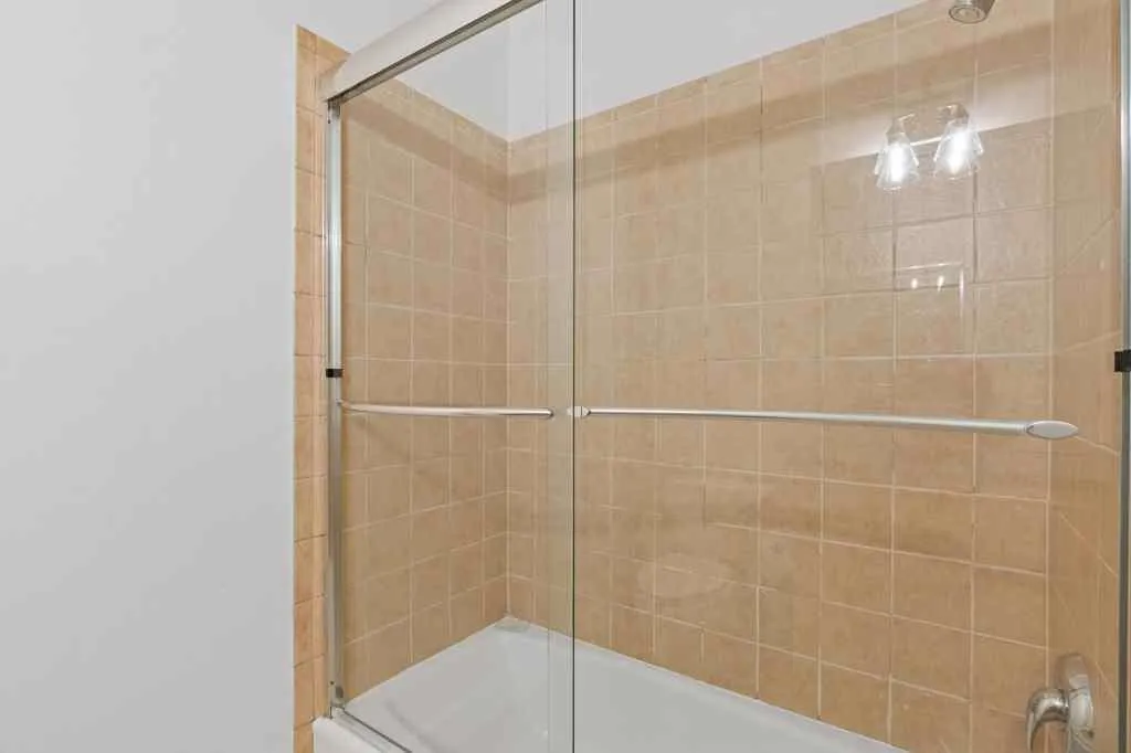 The second full bath has a single sink with extra counter space, and a tile shower with a glass enclosure.