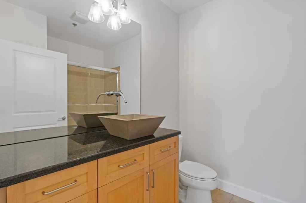 The second full bath has a single sink with extra counter space, and a tile shower with a glass enclosure.