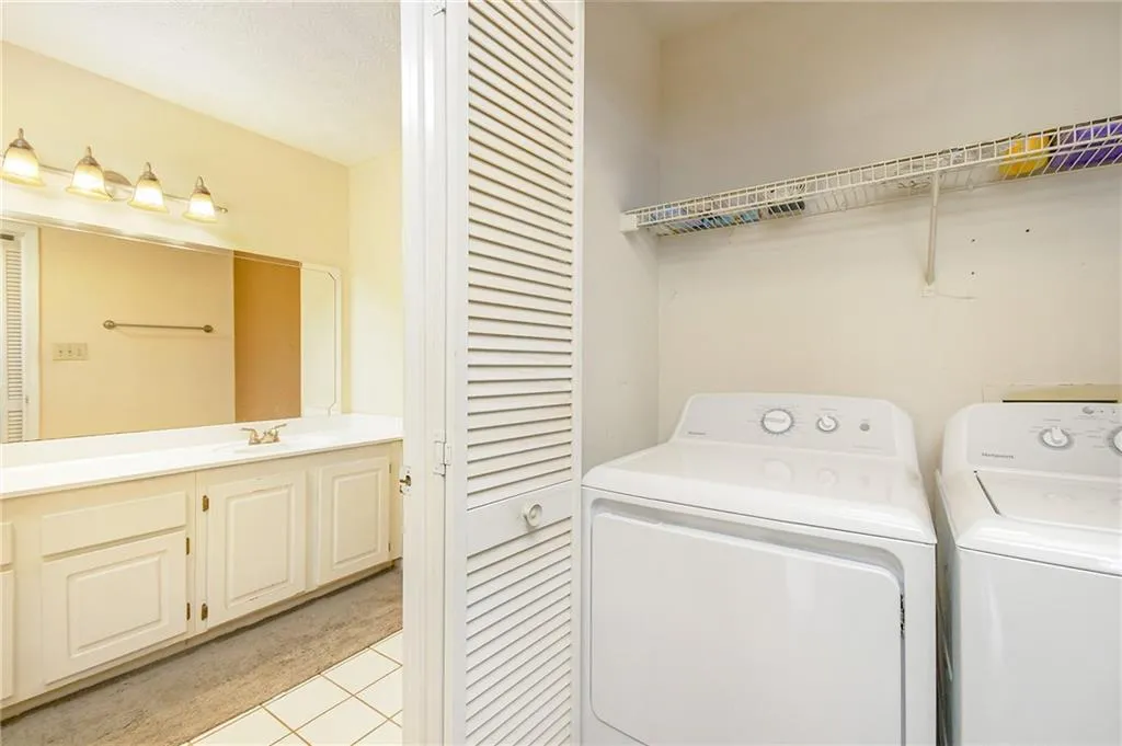 Washroom with laundry area, washer and dryer, and a sink