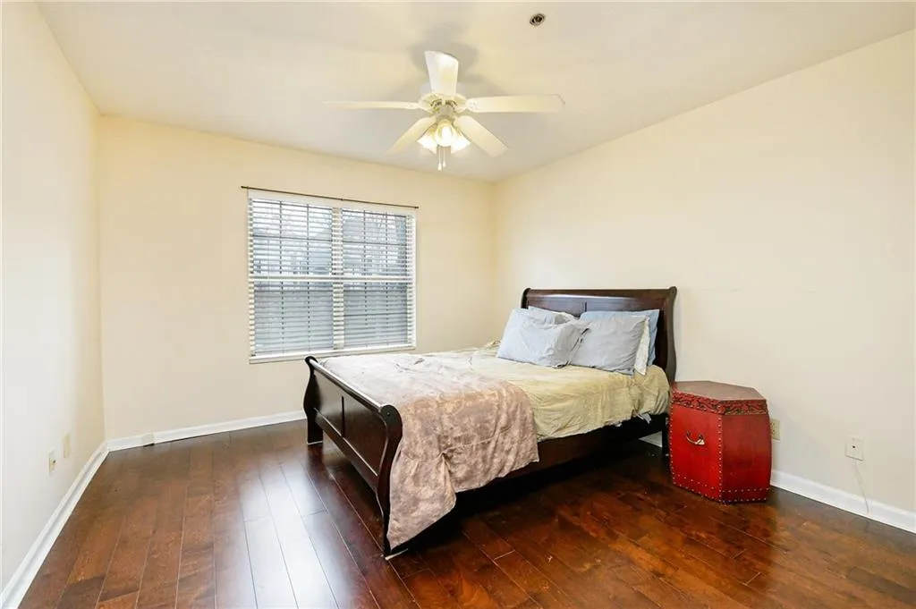 Bedroom featuring a ceiling fan, baseboards, and wood-type flooring