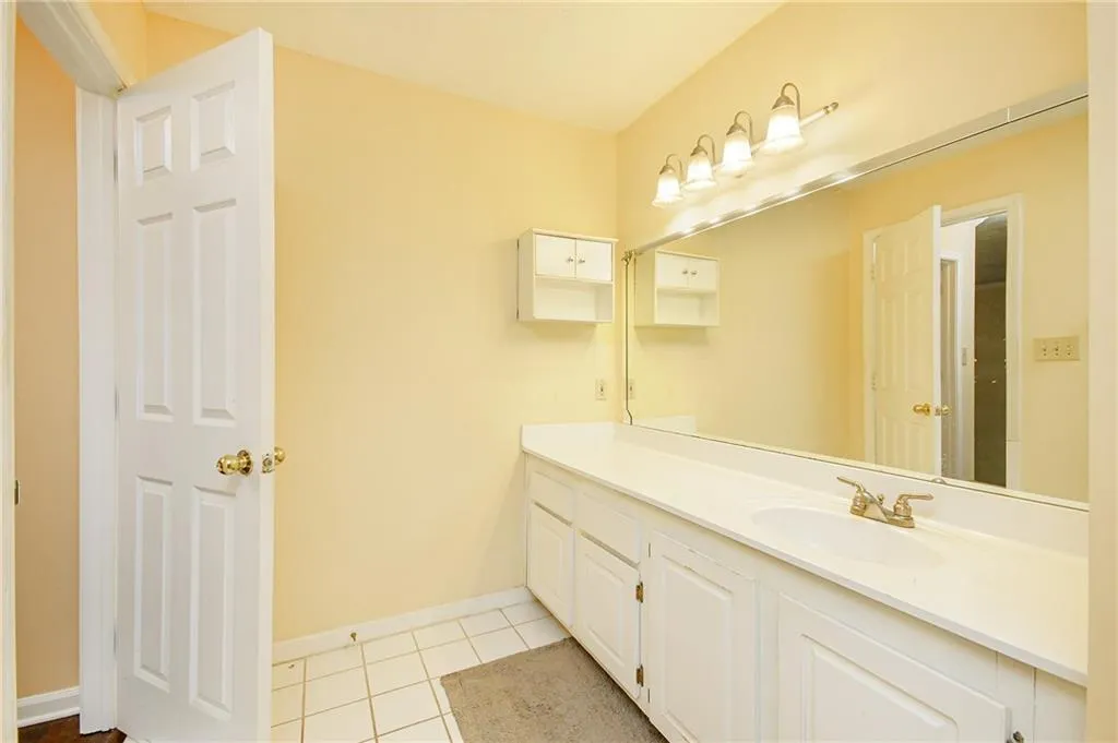Bathroom featuring tile patterned flooring, vanity, and baseboards