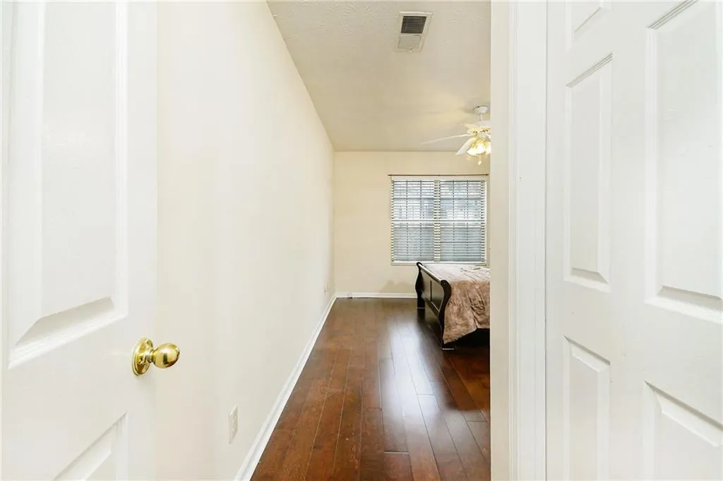 Hall featuring visible vents, baseboards, and dark wood-style flooring