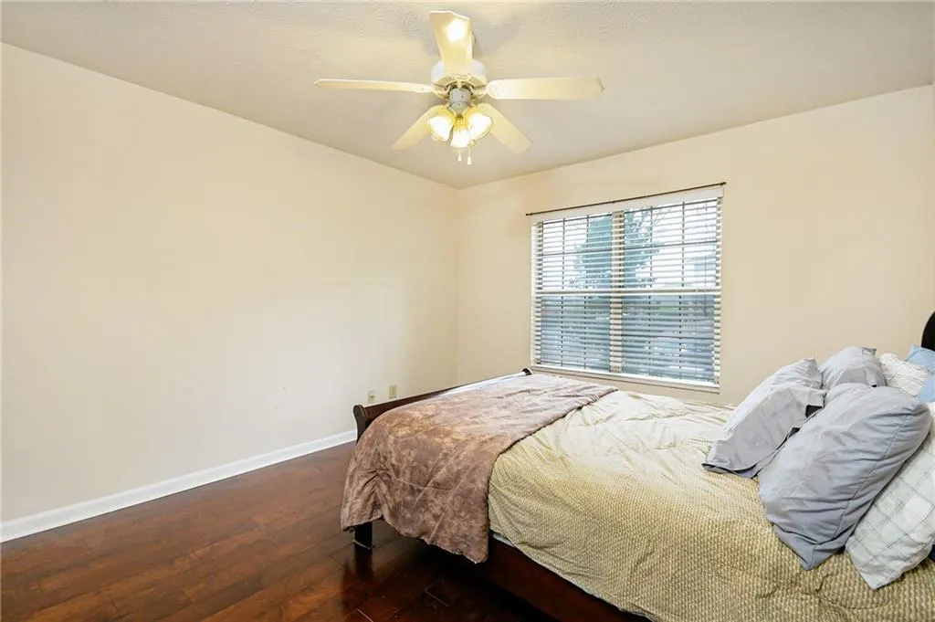 Bedroom featuring ceiling fan, baseboards, and hardwood / wood-style floors