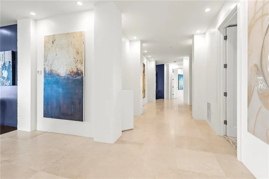Natural stone floor and recessed lighting in this contemporary foyer
