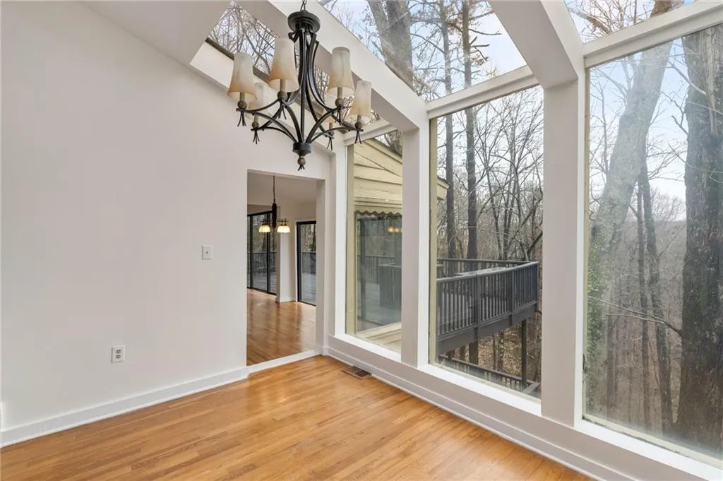 Unfurnished sunroom featuring plenty of natural light and a chandelier