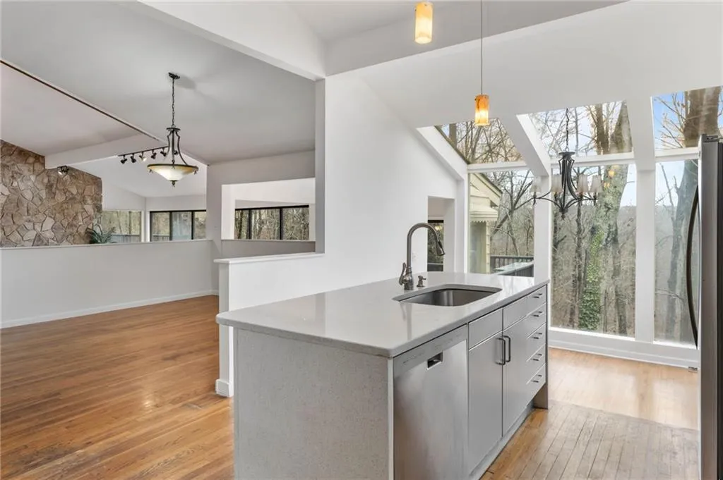 Kitchen featuring sink, decorative light fixtures, appliances with stainless steel finishes, plenty of natural light, and light hardwood / wood-style floors