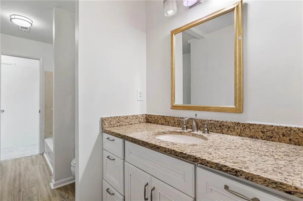 Full bathroom featuring shower / bath combination, hardwood / wood-style floors, vanity, and toilet