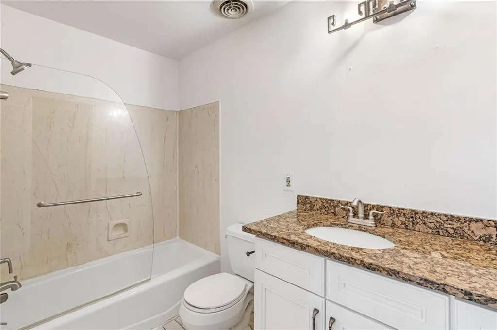 Full bathroom featuring tile flooring, shower / bath combination, vanity, and toilet