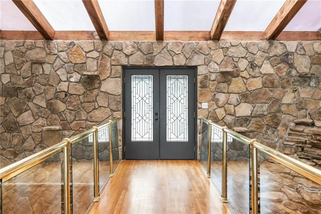 Foyer with beam ceiling, light wood-type flooring, and french doors