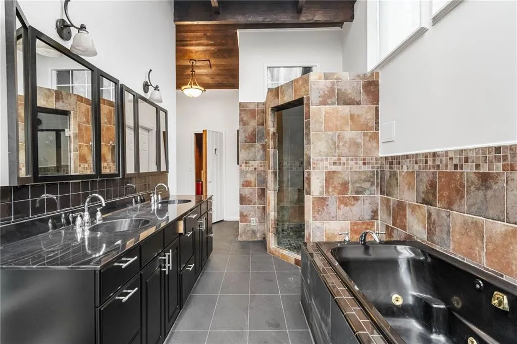 Bathroom featuring shower with separate bathtub, beamed ceiling, tile flooring, and tile walls