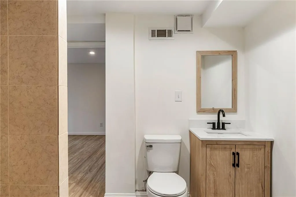 Bathroom with hardwood / wood-style floors, vanity, and toilet