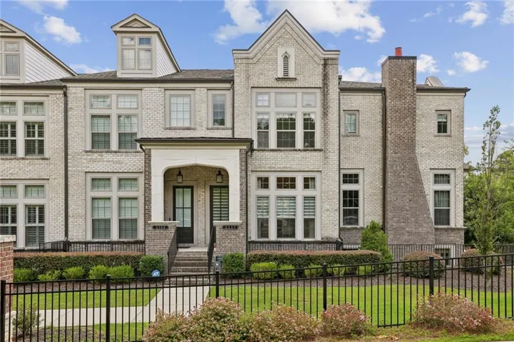 Three-story brick townhome with lush greenspace in the front yard