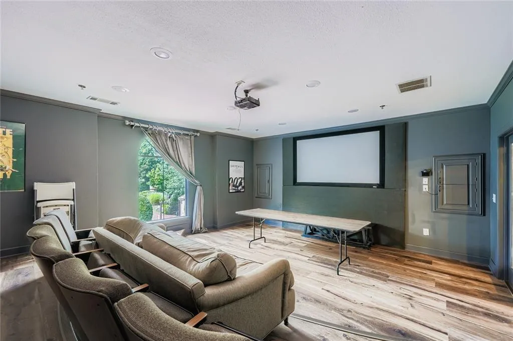Home theater featuring ornamental molding, wood finished floors, a textured ceiling, and recessed lighting