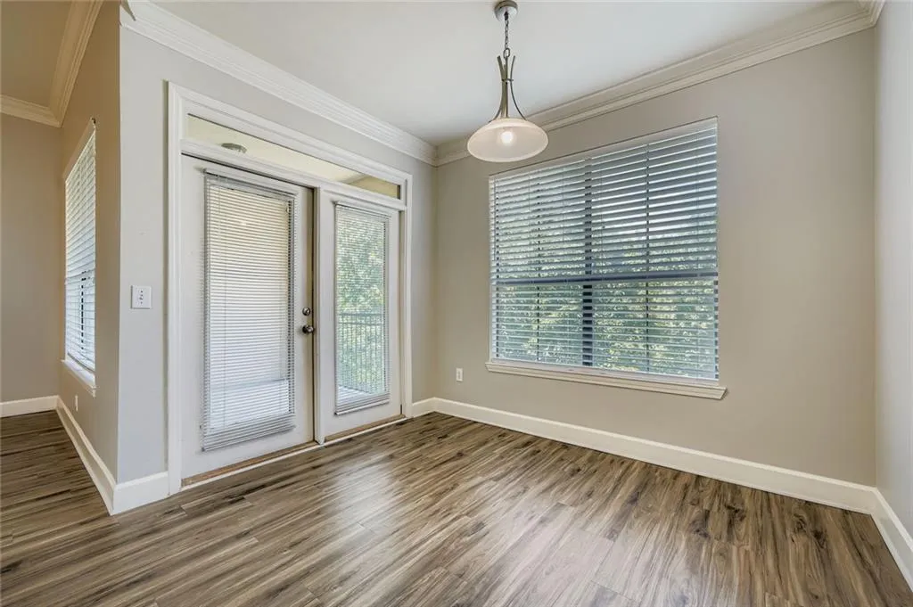 Unfurnished dining area with ornamental molding and wood finished floors