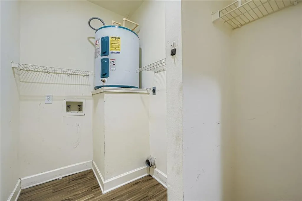 Laundry room featuring wood finished floors, hookup for an electric dryer, hookup for a washing machine, and water heater