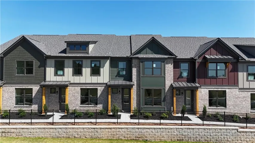 Contemporary townhome row featuring brick and siding exteriors