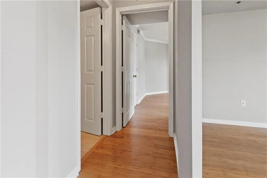 Hallway featuring light wood finished floors and baseboards