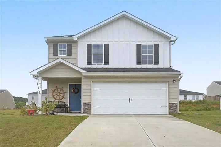 Two-story exterior with a two-car garage, stone accents, and a covered entry